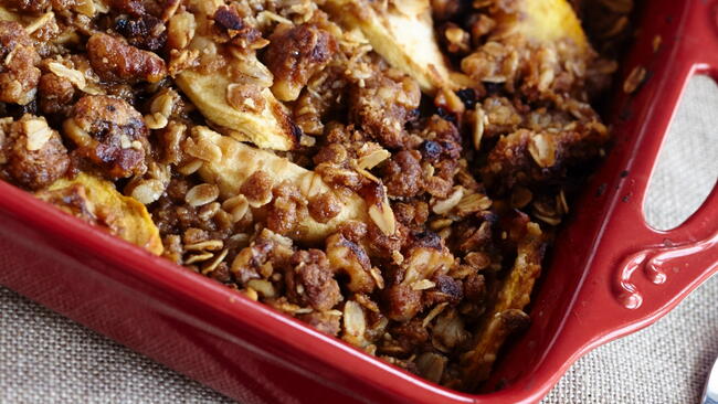 Close-up of peach crisp in a red baking pan 