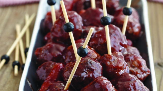bowl of sweet and tangy meatballs and sausage, on short skewers